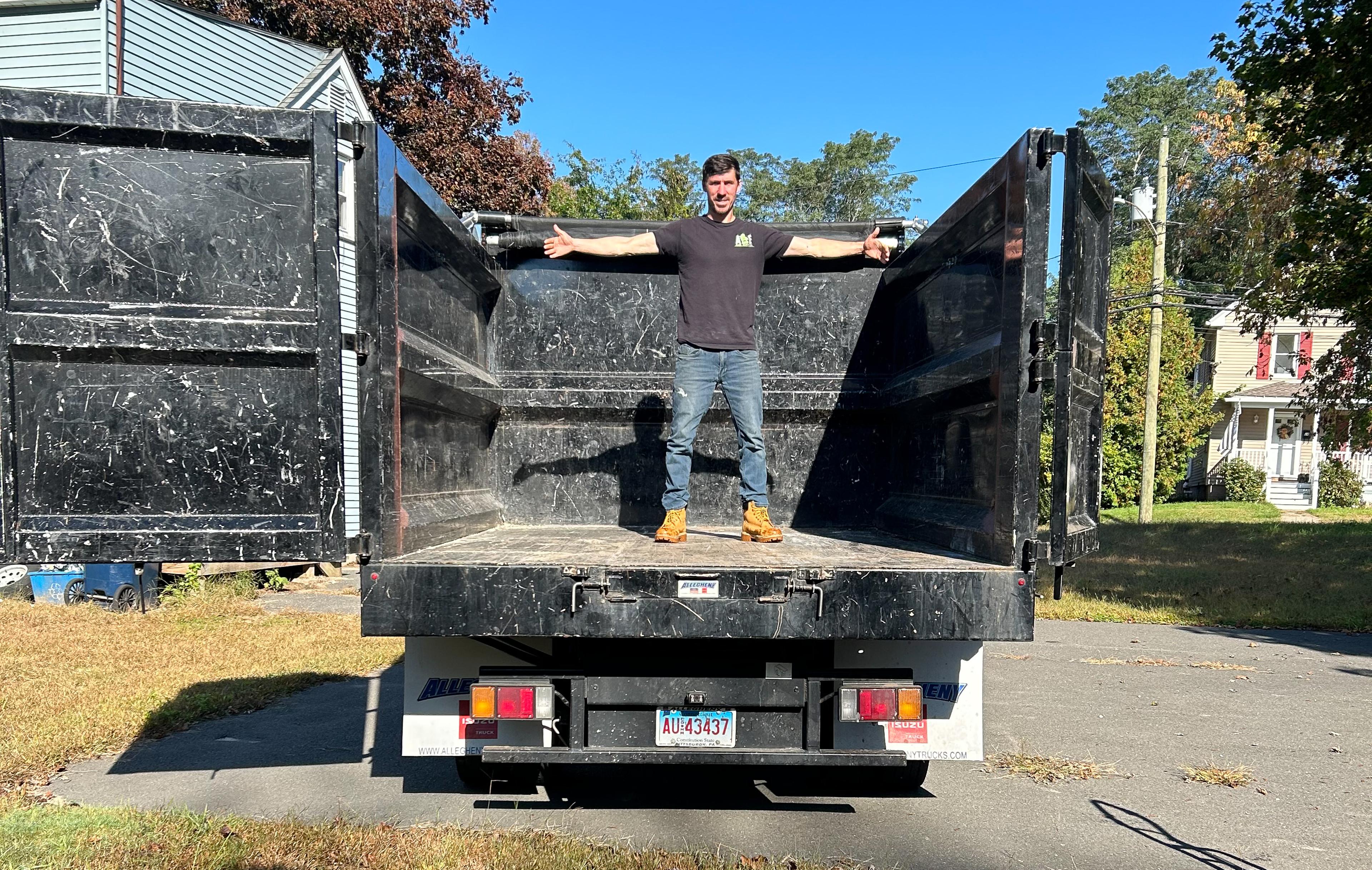 owner of a and e junk removal standing by truck with family