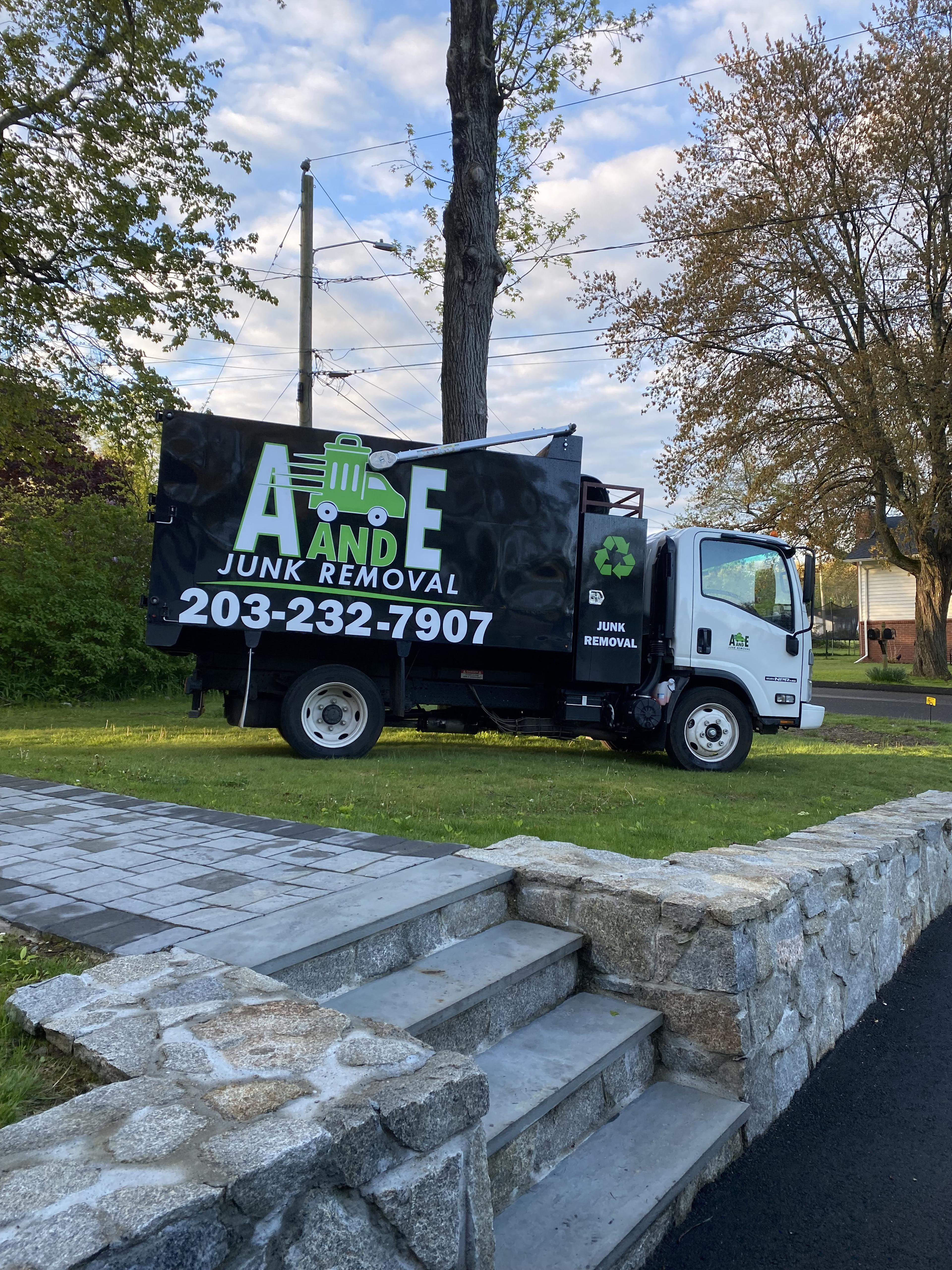 owner of a and e junk removal standing by truck with family